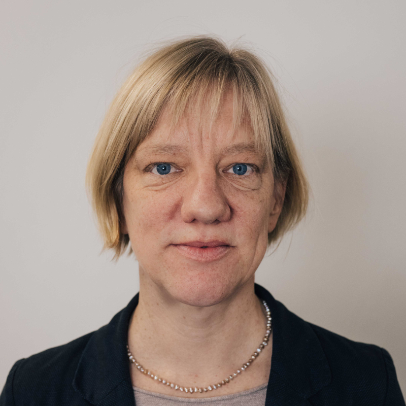 A woman in front of a white wall.